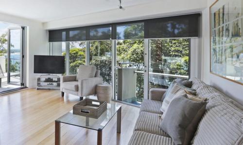a living room with a couch and a tv at Little Cove Court - Apt 10 in Noosa Heads