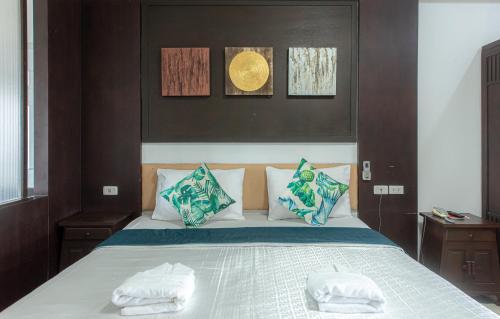 1 dormitorio con 1 cama con 2 toallas en The Wing Design Hotel en Bangkok