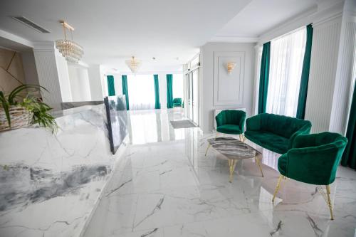 a living room with green chairs and a marble floor at Emerald Boutique Hotel in Târgu-Mureş