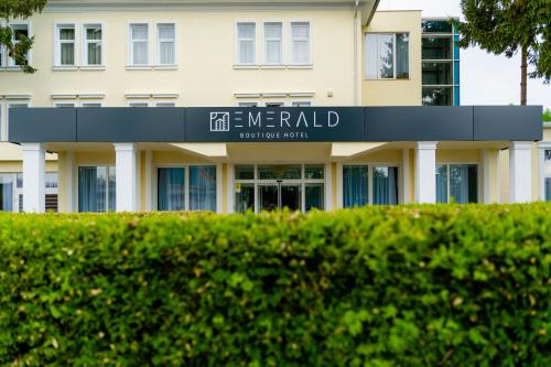 a building with a sign in front of it at Emerald Boutique Hotel in Târgu-Mureş