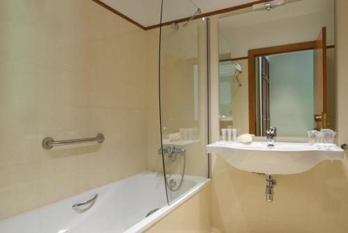a white bath tub sitting next to a white sink at Hotel Manantial in Caldes de Boi