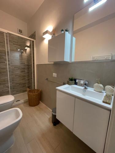 ein Badezimmer mit einem weißen Waschbecken und einer Toilette in der Unterkunft UN SOGNO NEL GOLFO DEI POETI in Lerici