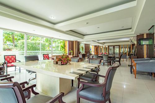a dining room with a large table and chairs at The Wing Design Hotel in Bangkok