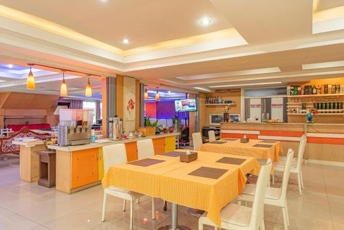 a restaurant with tables and chairs and a kitchen at The Wing Design Hotel in Bangkok