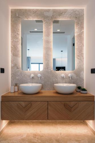 two sinks in a bathroom with two mirrors at Milestones Naxos in Naxos Chora
