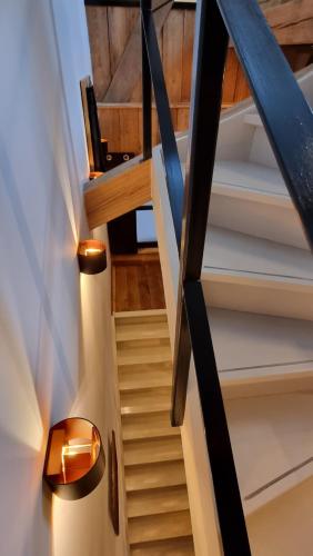 a staircase in a house with a wooden ceiling at Een vleugje wellness in de Voerstreek - Bed & Brocante Onder de Poort in Voeren