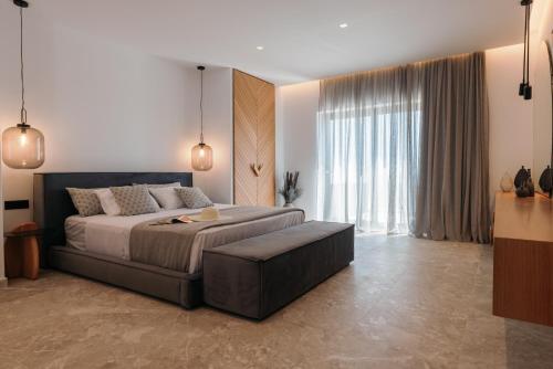 a bedroom with a bed and a large window at Milestones Naxos in Naxos Chora