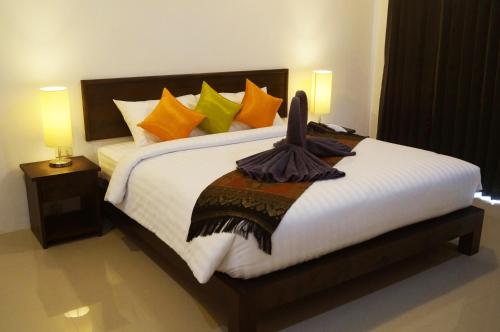 a bedroom with a large bed with colorful pillows at The Seashore Kamala Service Apartment in Kamala Beach