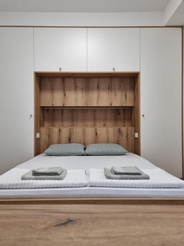 Un dormitorio con una cama grande con cabecero de madera. en Lovely 1-bedroom rental unit with free parking, en Skopje