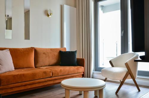 uma sala de estar com um sofá e uma cadeira em CITYSTAY Modernistyczny Apartament z tarasem w centrum Gdyni em Gdynia