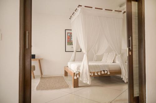 a bedroom with a bed with a canopy at Villa Sophia Seminyak in Seminyak