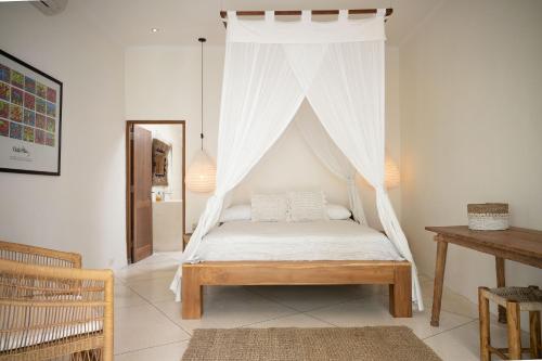 a bedroom with a bed with a mosquito net at Villa Sophia Seminyak in Seminyak