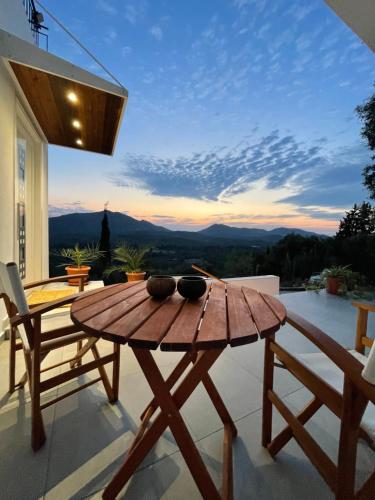 a wooden table and chairs on a patio with a view at Corfu Gaia View Studio in Episkopianá