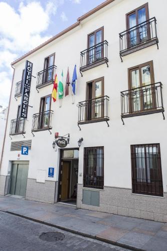 a white building with flags in front of it at Hotel de Los Faroles in Córdoba