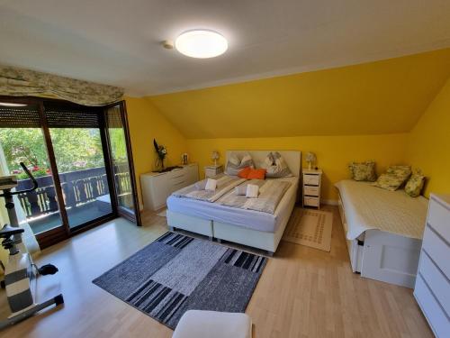 sypialnia z żółtymi ścianami, łóżkiem i oknem w obiekcie Haus Flora - Ferienwohnung Bodensdorf w mieście Bodensdorf