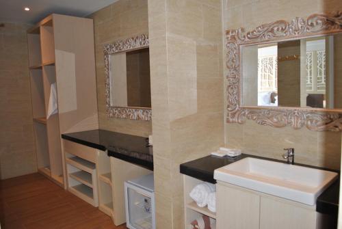 a bathroom with a sink and a mirror at Kori Maharani Villas - Lagoon Pool Access 3 in Siyut