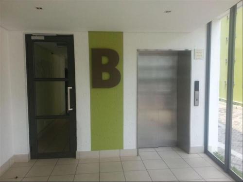 Dos ascensores en un edificio con una letra b en la pared en Perfect Traveler's apartment, en Johannesburgo
