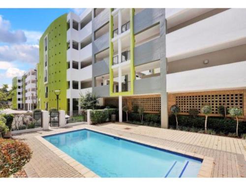 una piscina frente a un edificio en Perfect Traveler's apartment, en Johannesburgo
