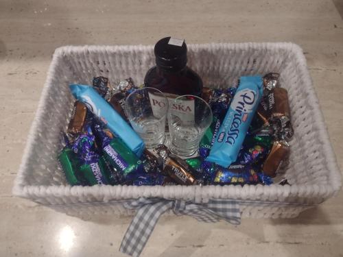 a basket full of candy and a bottle of alcohol at Apartament pod Chełmcem in Szczawno-Zdrój