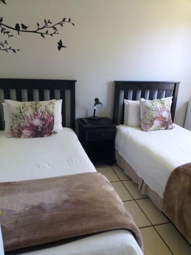 two beds sitting next to each other in a bedroom at African Sun Guest House in Molen Drift