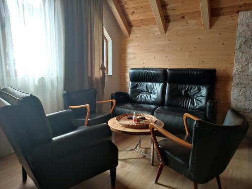 a living room with a couch and a table and chairs at Monte Pino Lux Apartments in Žabljak