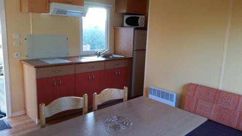 a small kitchen with a table and a sink at Camping Le Beaulieu in Puilboreau