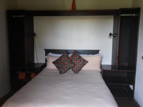 a bed with two pillows on top of it at African Sun Guest House in Molen Drift