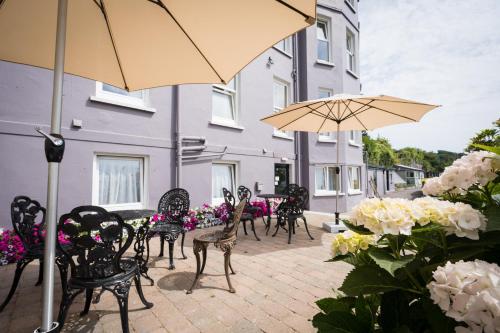 a patio area with chairs, tables and umbrellas at Gabriel House Guesthouse in Cork