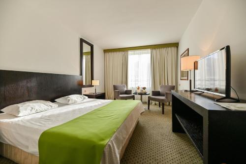 um quarto de hotel com uma cama grande e uma secretária em Hotel International em Rab