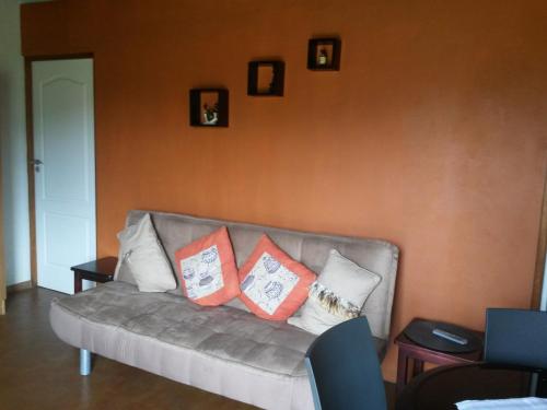 a couch with pillows on it in a living room at African Sun Guest House in Molen Drift