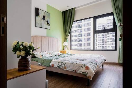 a bedroom with a bed and a vase of flowers at Capsule Vinhomes Ocean Park in Hanoi