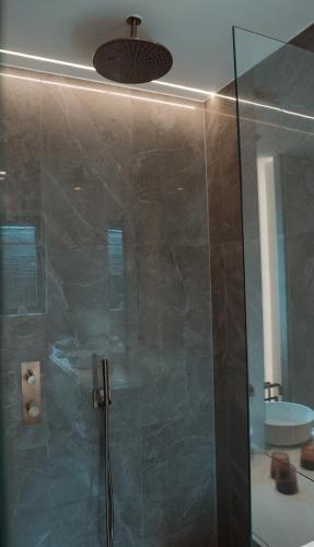 a bathroom with a shower with a glass door at B&B De Tiendeschuur in Evergem