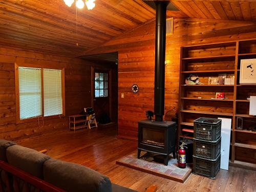 una sala de estar con estufa de leña en una cabaña en 帳 -TOBARI- en Dazaifu