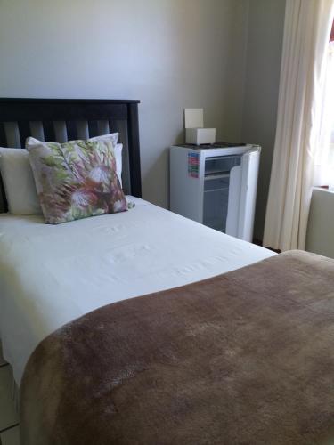 a bedroom with a bed with a pillow on it at African Sun Guest House in Molen Drift