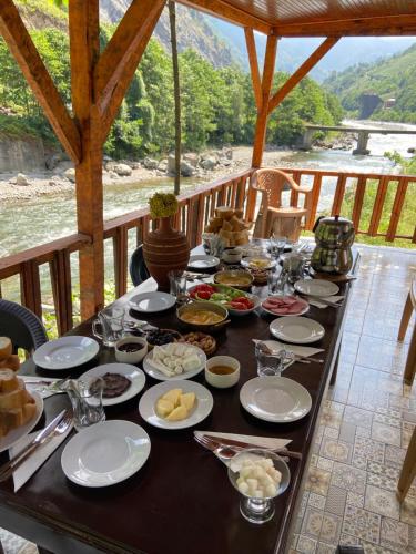 einen Tisch mit Essen drauf mit Blick auf einen Fluss in der Unterkunft Karadeniz Suit in Rize