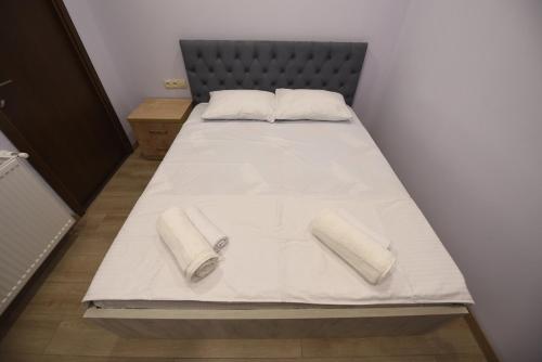 a bed with white sheets and pillows on it at Family Hotel Avlabar in Tbilisi City
