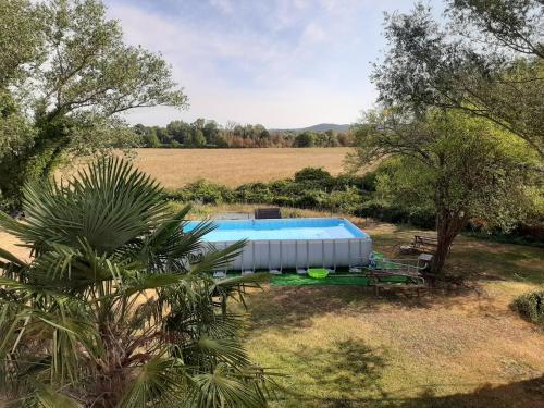 una piscina en medio de un campo con árboles en LOCATION APPART 45 M² - 2 CH AVEC JARDIN PRIVATIF en Gailhan