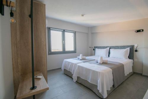 Heraclea Luxury Suites في نيا إيراكليا: غرفة نوم بسرير كبير ونافذة