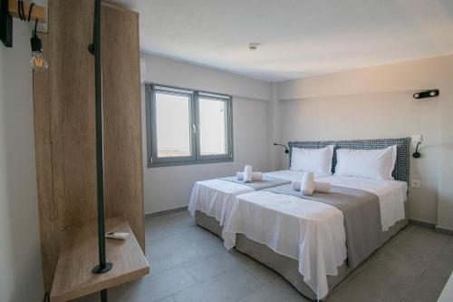 a bedroom with a large bed and a window at Heraclea Luxury Suites in Nea Irakleia