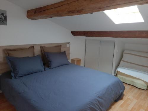 Un dormitorio con una cama azul y una ventana en LOCATION APPART 45 M² - 2 CH AVEC JARDIN PRIVATIF, en Gailhan