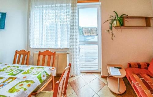 Zimmer mit einem Tisch, Stühlen und einem Fenster in der Unterkunft Gorgeous Apartment In Polchowo With Wifi in Połchowo
