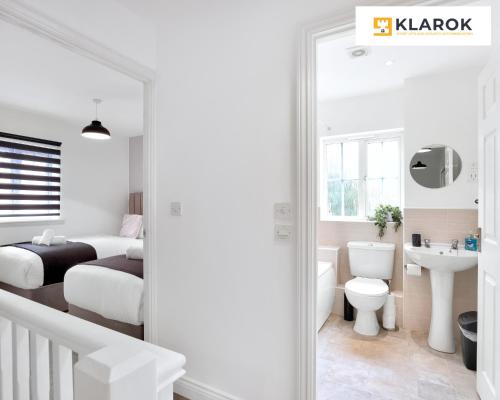 Schlafzimmer mit einem Bett, einem WC und einem Waschbecken in der Unterkunft LONG STAYS 30pct OFF - Comfy 3 Bed House near City Centre - PS4 - PARKING By Klarok Short Lets & Serviced Accommodation in Peterborough