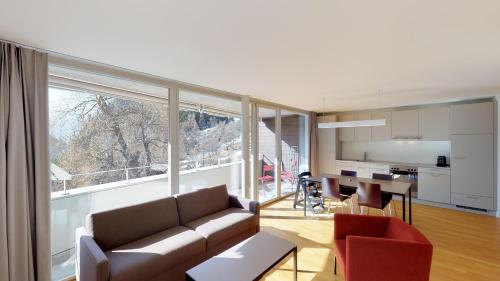 a living room with a couch and a dining room at Reka-Feriendorf Blatten-Belalp in Blatten bei Naters