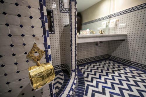 a bathroom with a gold object hanging on the wall at Riad Sidrat Fes in Fès