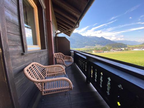 two wicker chairs sitting on the porch of a house at Waldruh in Wiesing