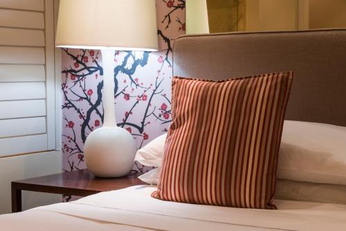 a bed with a pillow and a lamp on a table at Royal Palm Hotel in Durban