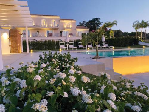 トロペアにあるIl Borghetto Creative Resortのスイミングプールと花を備えたヴィラ