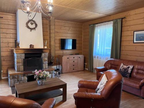 a living room with leather furniture and a fireplace at Vilni Vitry in Osmoloda