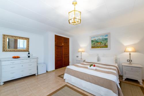a bedroom with a bed and a dresser and a mirror at Finca Hotel Rural Predio Son Serra in Can Picafort