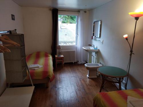 Zimmer mit einem Bett, einem Waschbecken und einem Fenster in der Unterkunft Le Lutin in Luchon